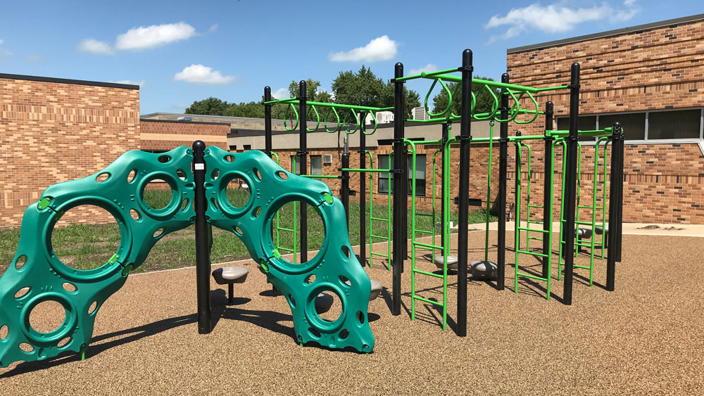 Playground climbing structures on poured-in-place rubber surfacing